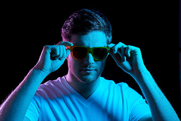 Image showing man in sunglasses over ultra violet neon lights