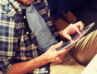 Image showing close up of man with tablet pc sitting at cafe