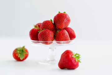 Image showing strawberries on glass stand over white background