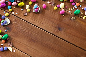 Image showing chocolate eggs and candy drops on wooden table