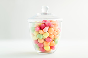 Image showing glass jar with candy drops over white background