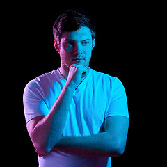 Image showing thinking man over neon lights in dark room