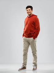 Image showing young man in red hoodie over grey background