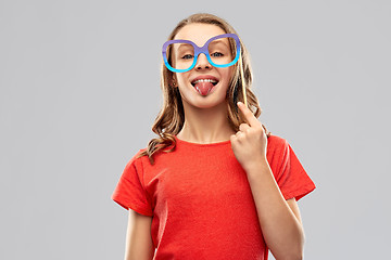 Image showing teenage girl with party prop showing tongue