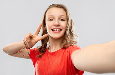 Image showing smiling woman taking selfie and showing peace sign