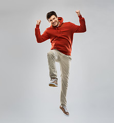 Image showing man in hoodie jumping and celebrating success