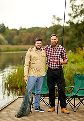 Image showing friends with fishing rods and net at lake or river