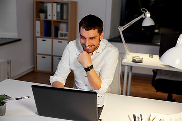 Image showing businessman with laptop working at night office