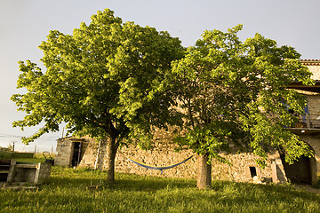 Image showing hammock in trees and old stone farmhouse france