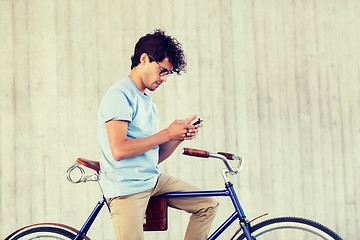 Image showing man with smartphone and fixed gear bike on street