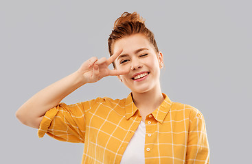 Image showing smiling red haired teenage girl showing peace