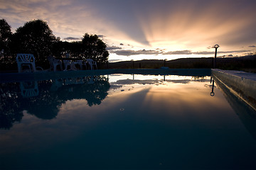 Image showing reflection of sunset over swimming pool