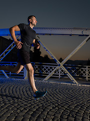 Image showing man jogging across the bridge in the city