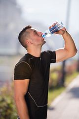 Image showing man drinking water from a bottle after jogging