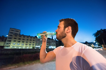 Image showing man drinking water after running session