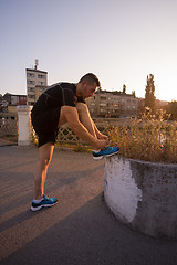 Image showing man tying running shoes laces