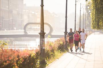 Image showing group of young people jogging in the city