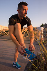 Image showing man tying running shoes laces