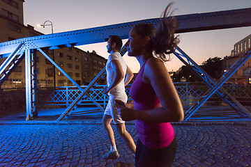 Image showing couple jogging across the bridge in the city