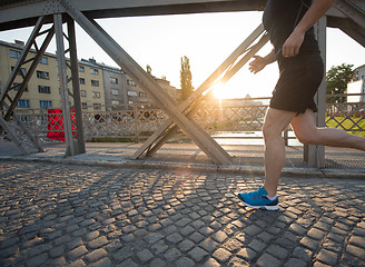 Image showing man jogging across the bridge at sunny morning