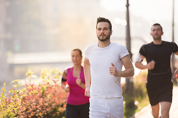 Image showing group of young people jogging in the city