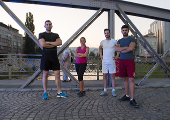 Image showing group of young people jogging across the bridge