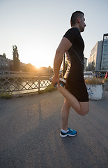 Image showing athlete man warming up and stretching