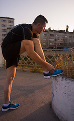 Image showing man tying running shoes laces