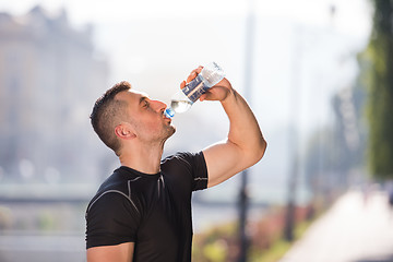 Image showing man drinking water from a bottle after jogging
