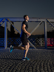 Image showing man jogging across the bridge in the city