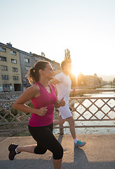 Image showing young couple jogging across the bridge in the city