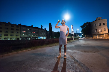 Image showing man drinking water after running session