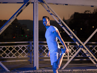 Image showing man jogging across the bridge in the city