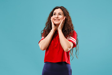 Image showing The happy business woman standing and smiling against blue background.