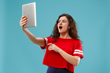 Image showing The happy businesswoman with red laptop on blue