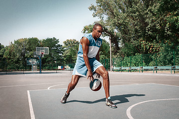 Image showing Picture of young confused african basketball player practicing