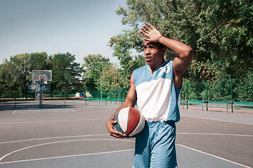 Image showing Picture of young confused african basketball player practicing