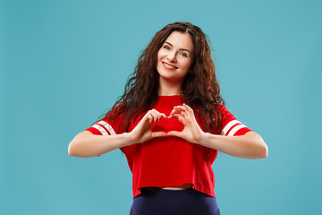 Image showing The happy business woman standing and smiling against blue background.