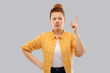 Image showing red haired teenage girl pointing finger up