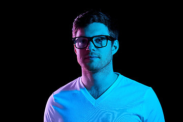 Image showing man in glasses over neon lights in dark room