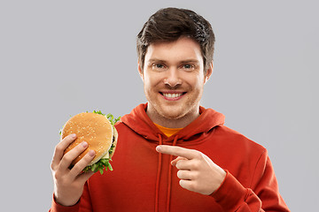 Image showing happy young man showing hamburger