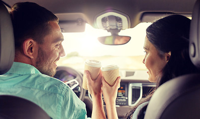 Image showing happy man and woman driving in car with coffee