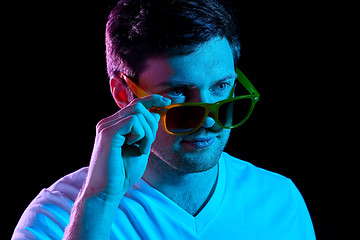 Image showing man in sunglasses over ultra violet neon lights