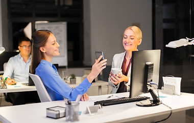 Image showing businesswomen with smartphone late at night office