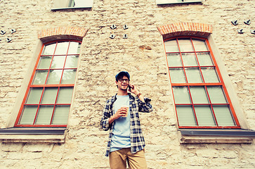 Image showing man with smartphone drinking coffee on city street