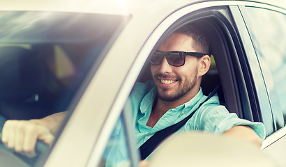 Image showing happy smiling man in sunglasses driving car