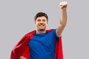 Image showing man in red superhero cape over grey background