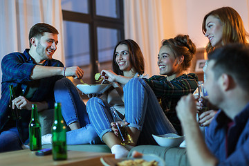 Image showing friends with drinks and snacks watching tv at home