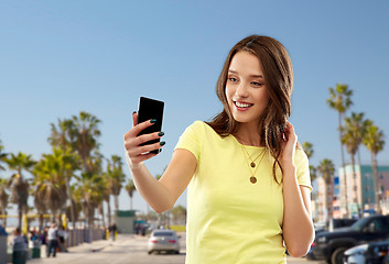 Image showing teen girl takes selfie by cell over venice beach