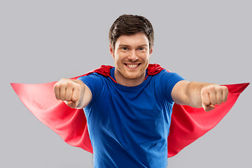 Image showing man in red superhero cape over grey background